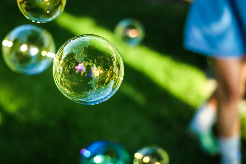 a person walking past some bubbles on the grass