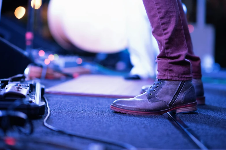 the legs and feet of people with boots and headphones