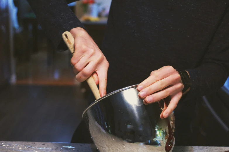 a person mixing liquid with a wooden stick