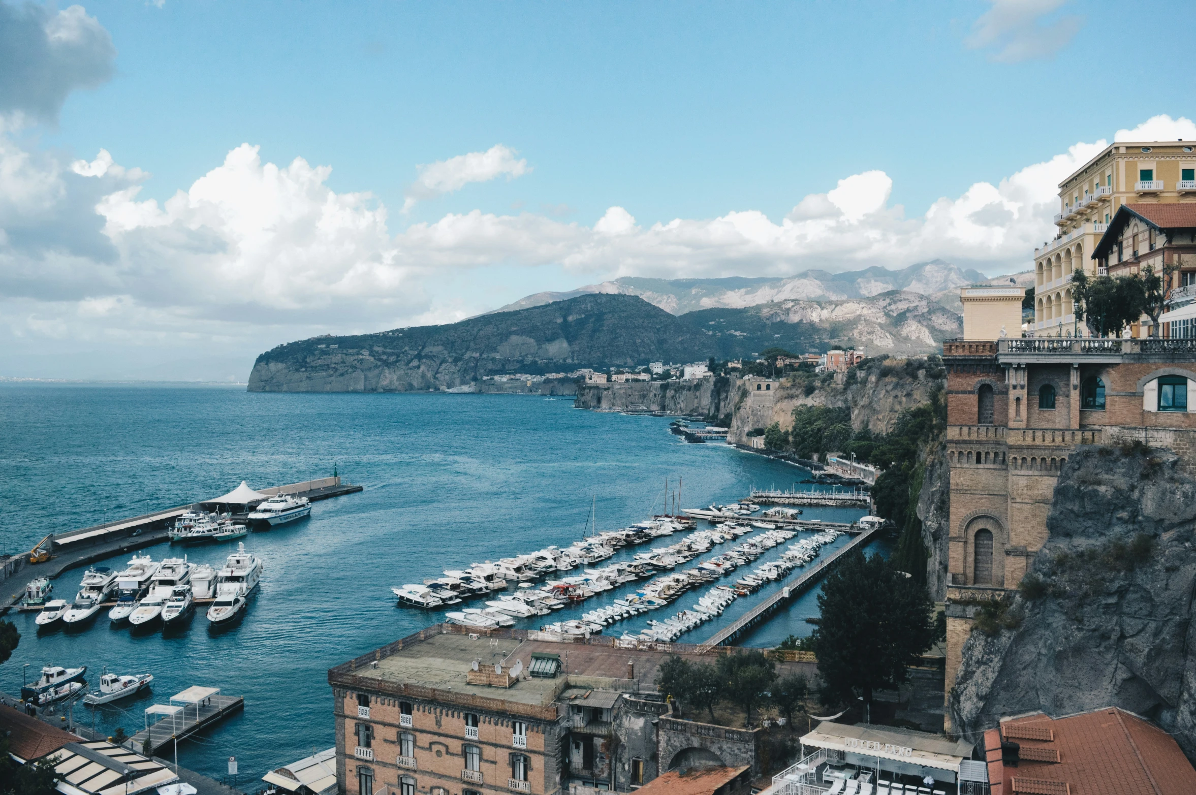 a harbor on the coast full of small boats