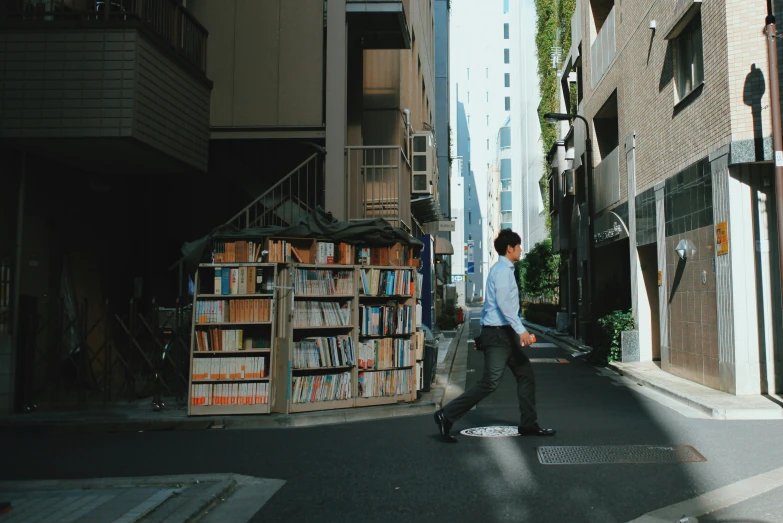 young man crosswalk in urban city with bookshelves