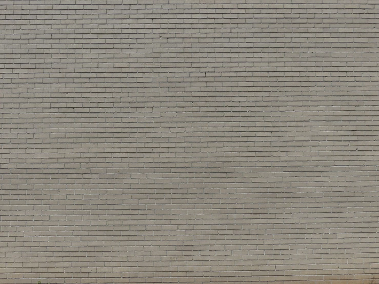 there is a large white umbrella standing in front of a brick wall