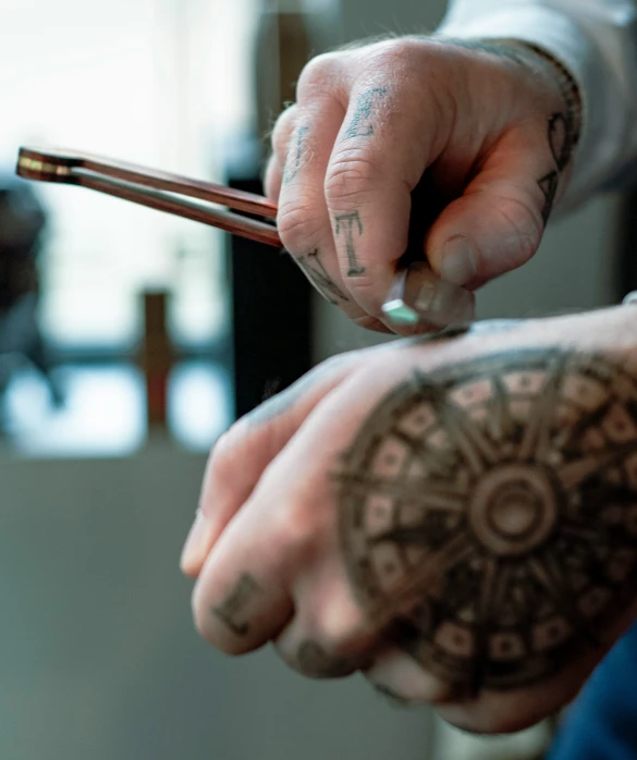 two hands are seen as the person holds the handle of a brown stick