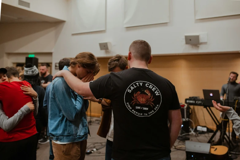 several people are dancing at a conference, some have microphones and others with arms around each other