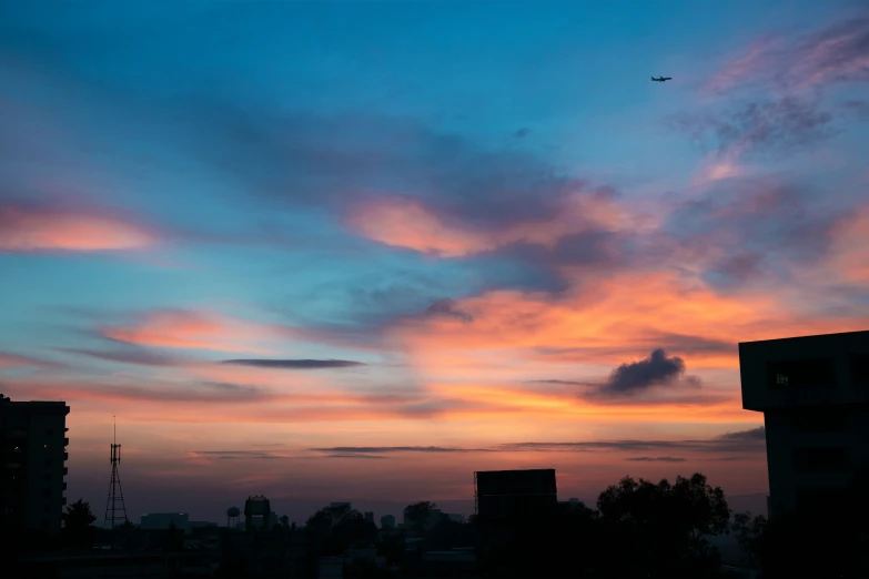 a colorful sunset, with a plane in the background