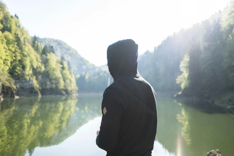 man looking at scenic river in the forest