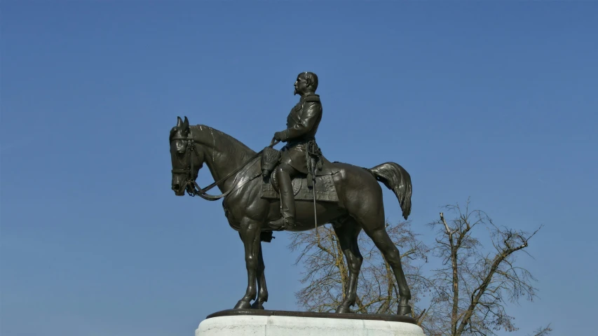 the large statue of a man riding on the back of a brown horse