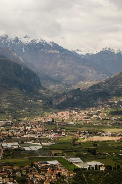 the view of a large city below mountain tops