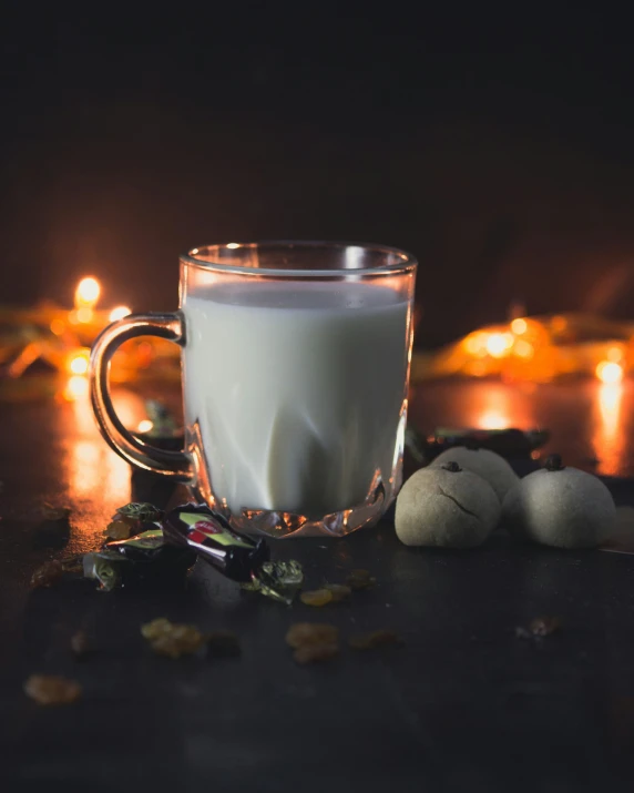 a cup of milk sitting on top of a table next to other items