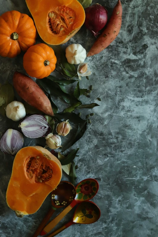 an arrangement of pumpkins and onions are displayed