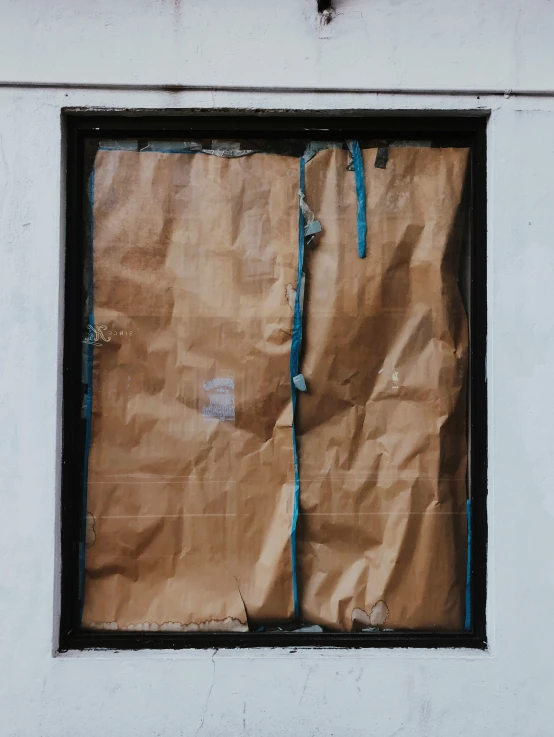 a partially painted paper bag is displayed in a window