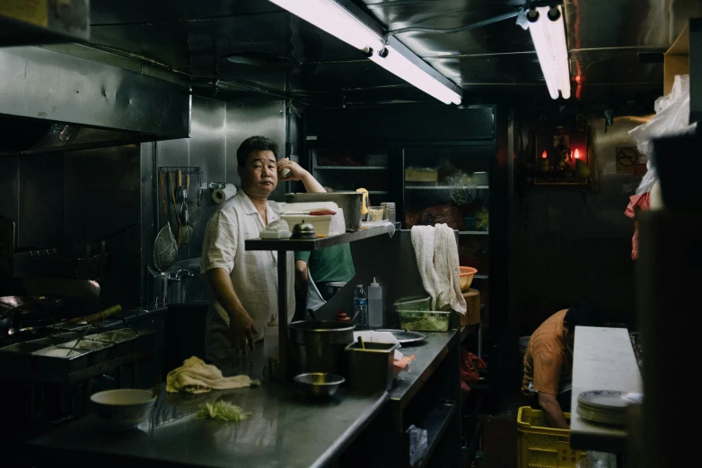 a man who is wearing an apron talking on a phone