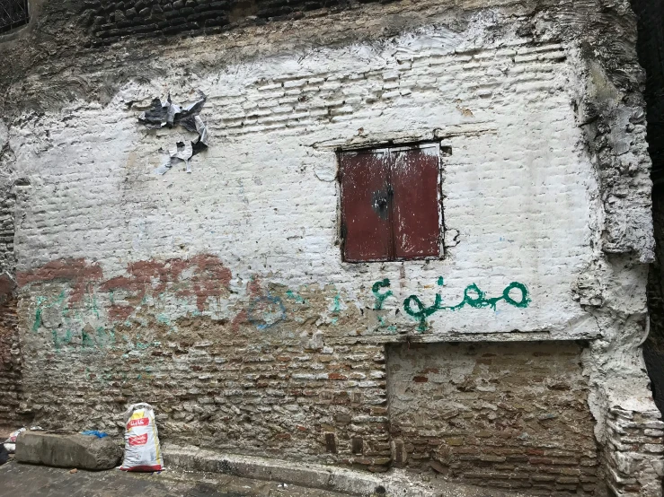 an old stone building with graffiti on the side