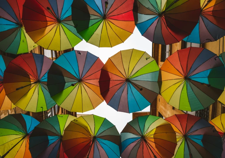 many colorful umbrellas are lined up on the street