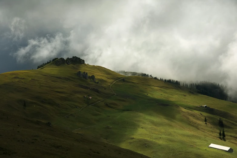 a house on a lush green hill under clouds