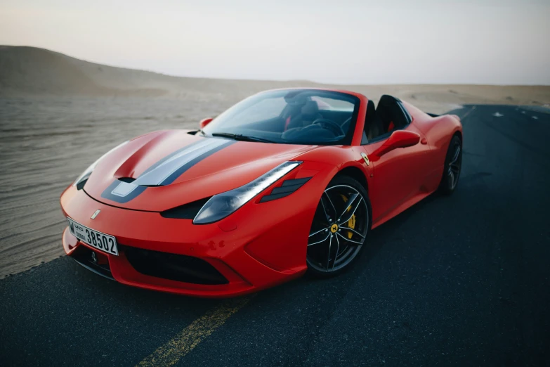 a red sports car driving on a road