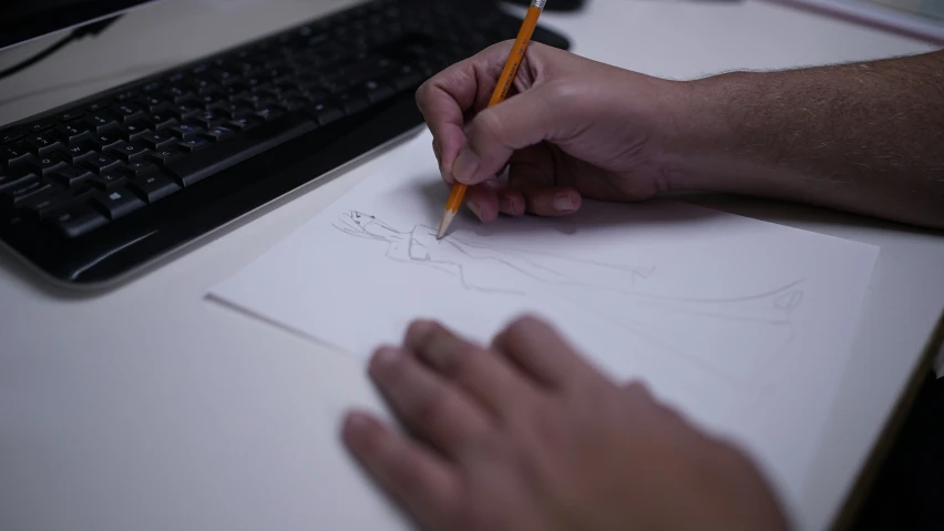 a man writing with pencil and a drawing paper