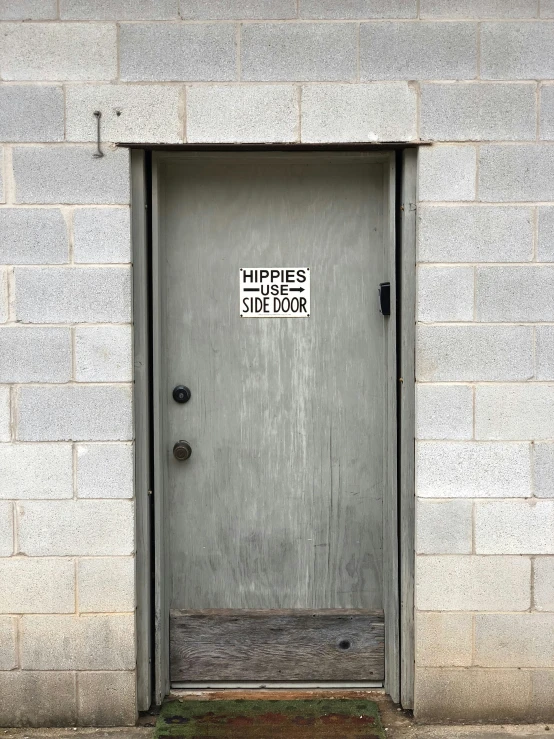 a large door is next to a grey brick wall