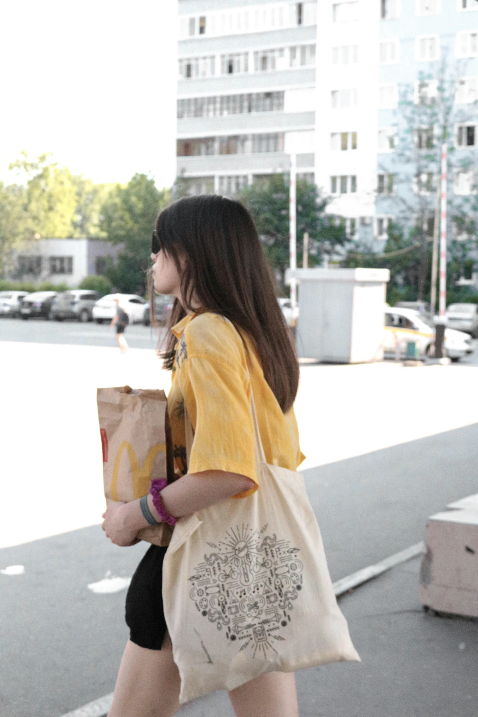 there is a young woman walking down the street with a shopping bag