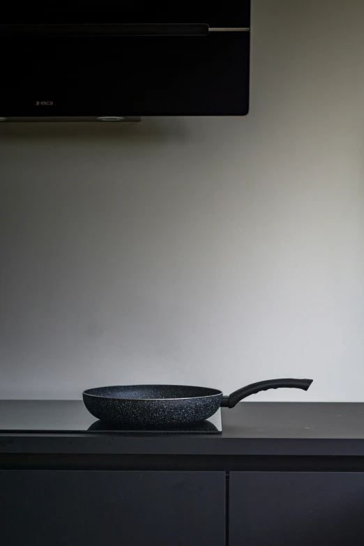 a frying pan sits on a counter next to a flat screen television