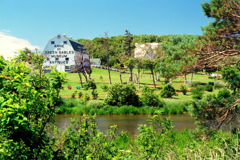 a building in the background with trees and grass on the ground