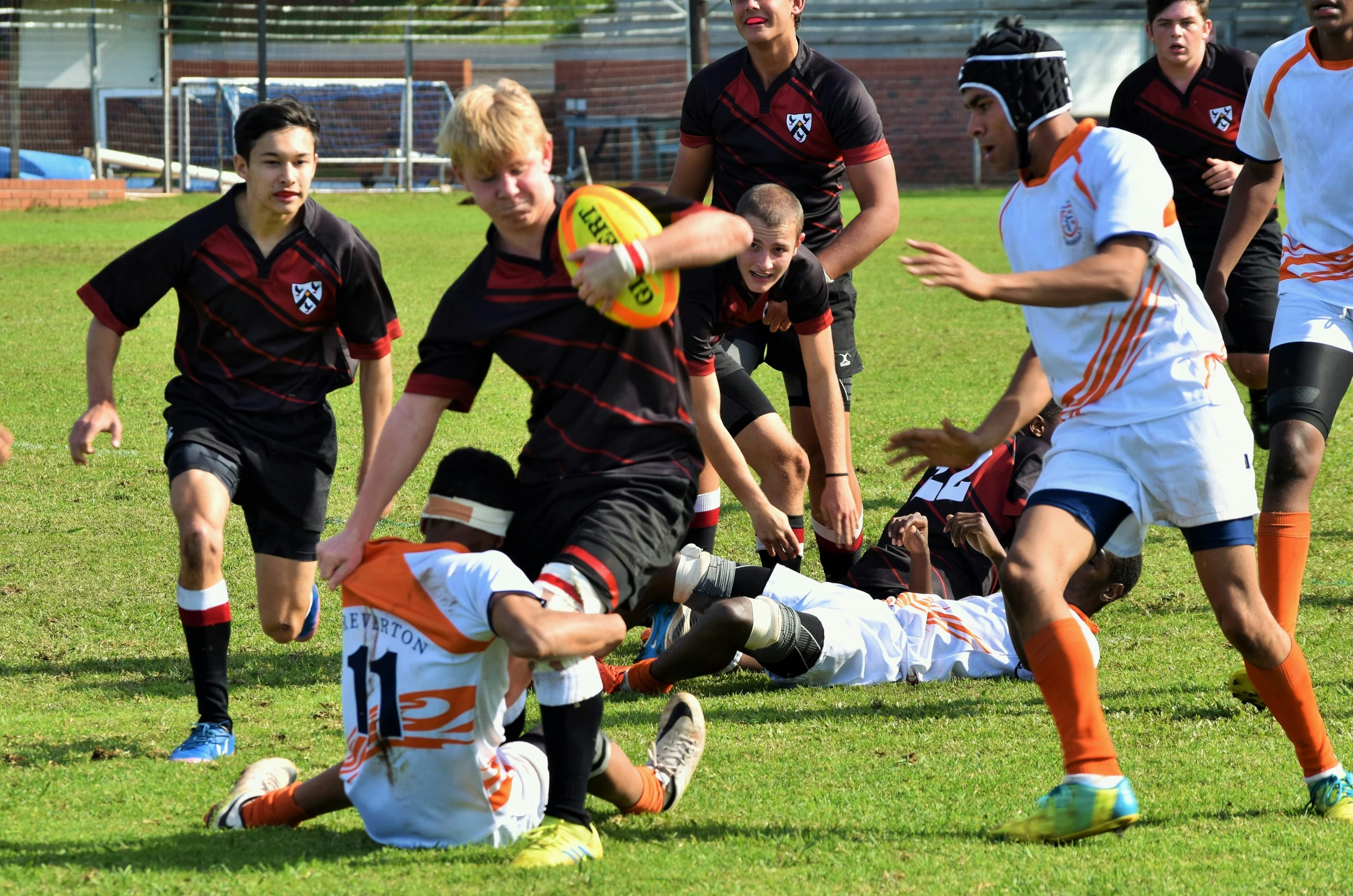 several soccer players have fallen to the ground and look to their left