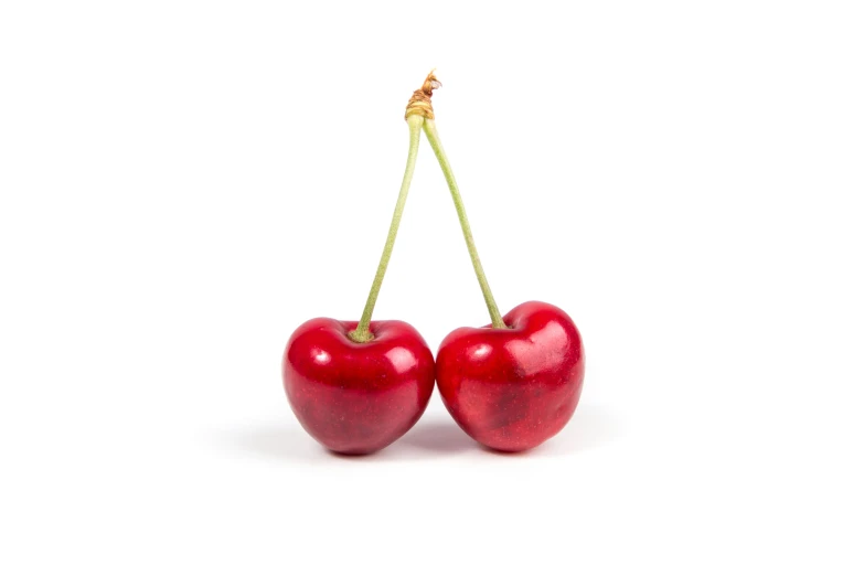 two cherry fruit hanging from a yellow wire