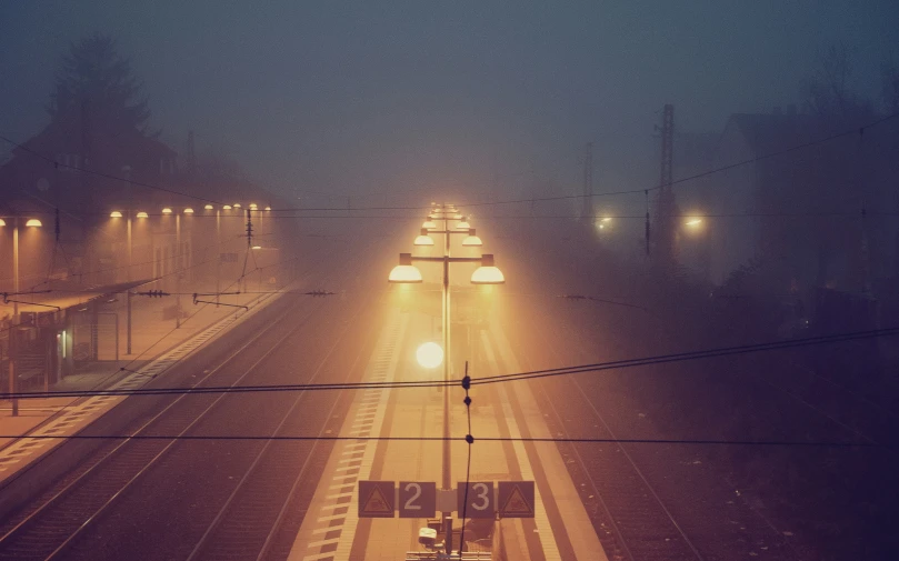 a train crossing over an intersection with traffic lights on a snowy night