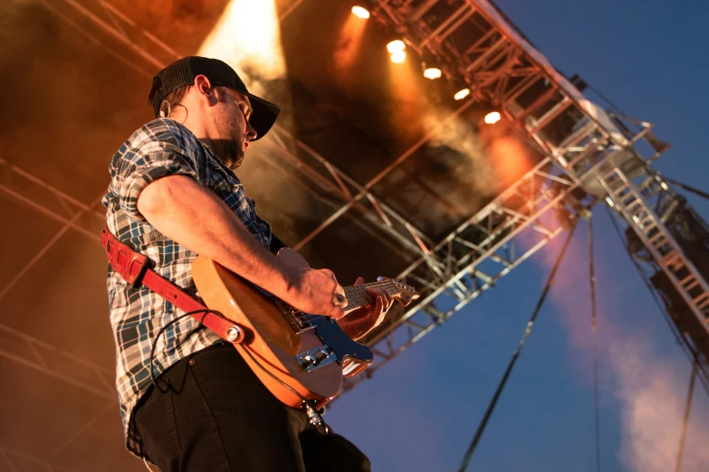 a man playing a guitar while standing on stage