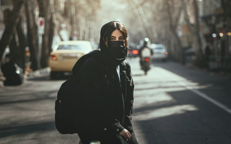 a man walking down the street wearing a mask