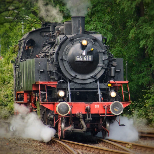 a train moving on the tracks with trees in the background