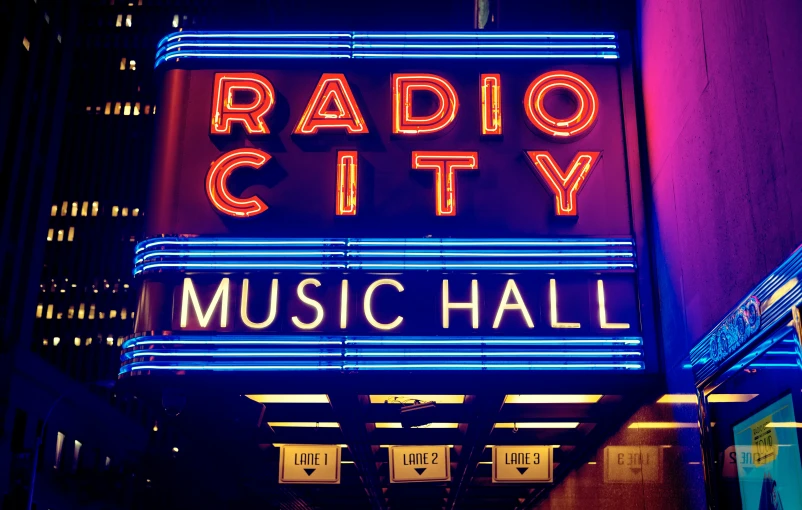 a theater sign that is lit up by neon lights