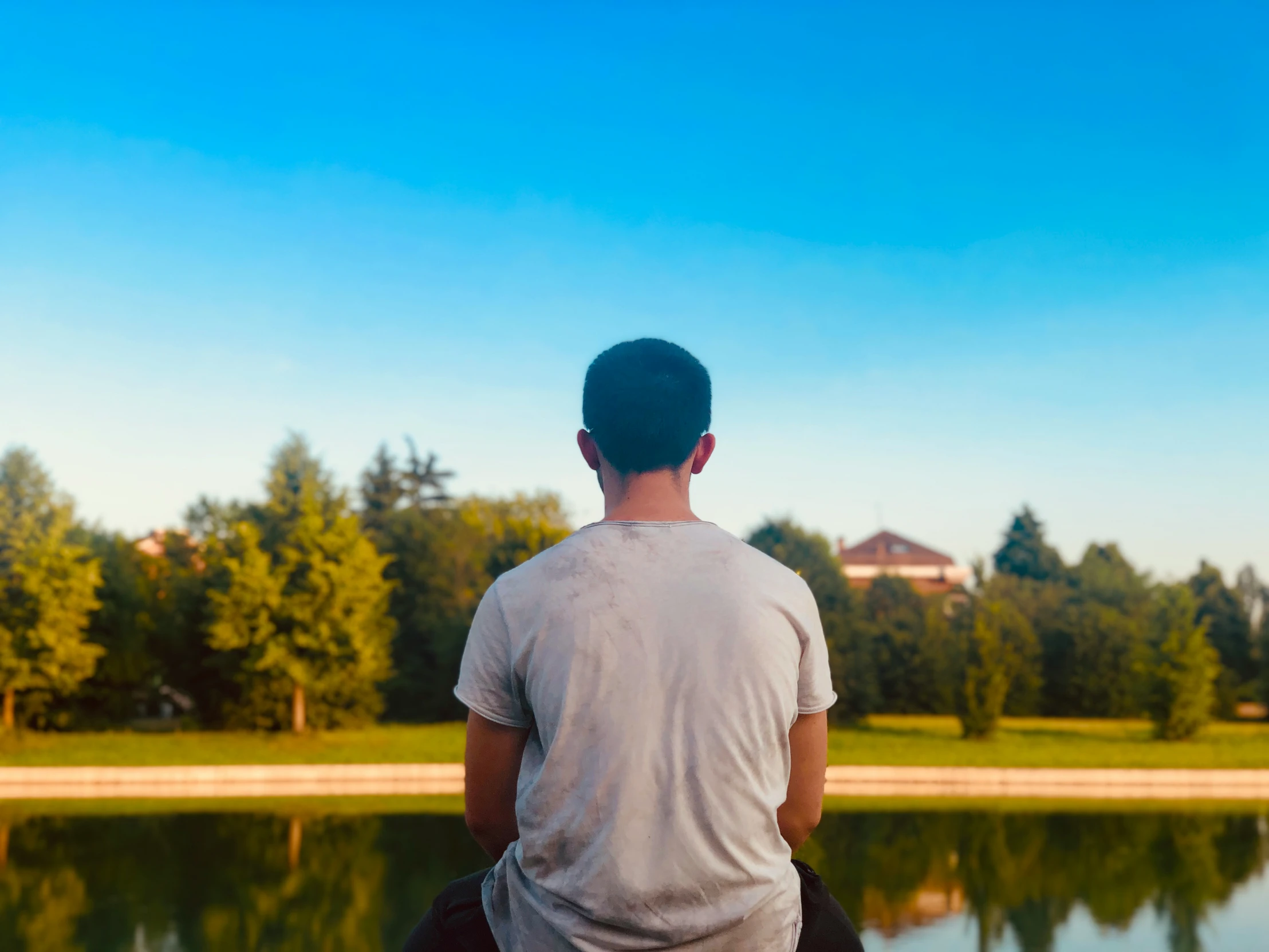 a man stands by the water looking at a lake