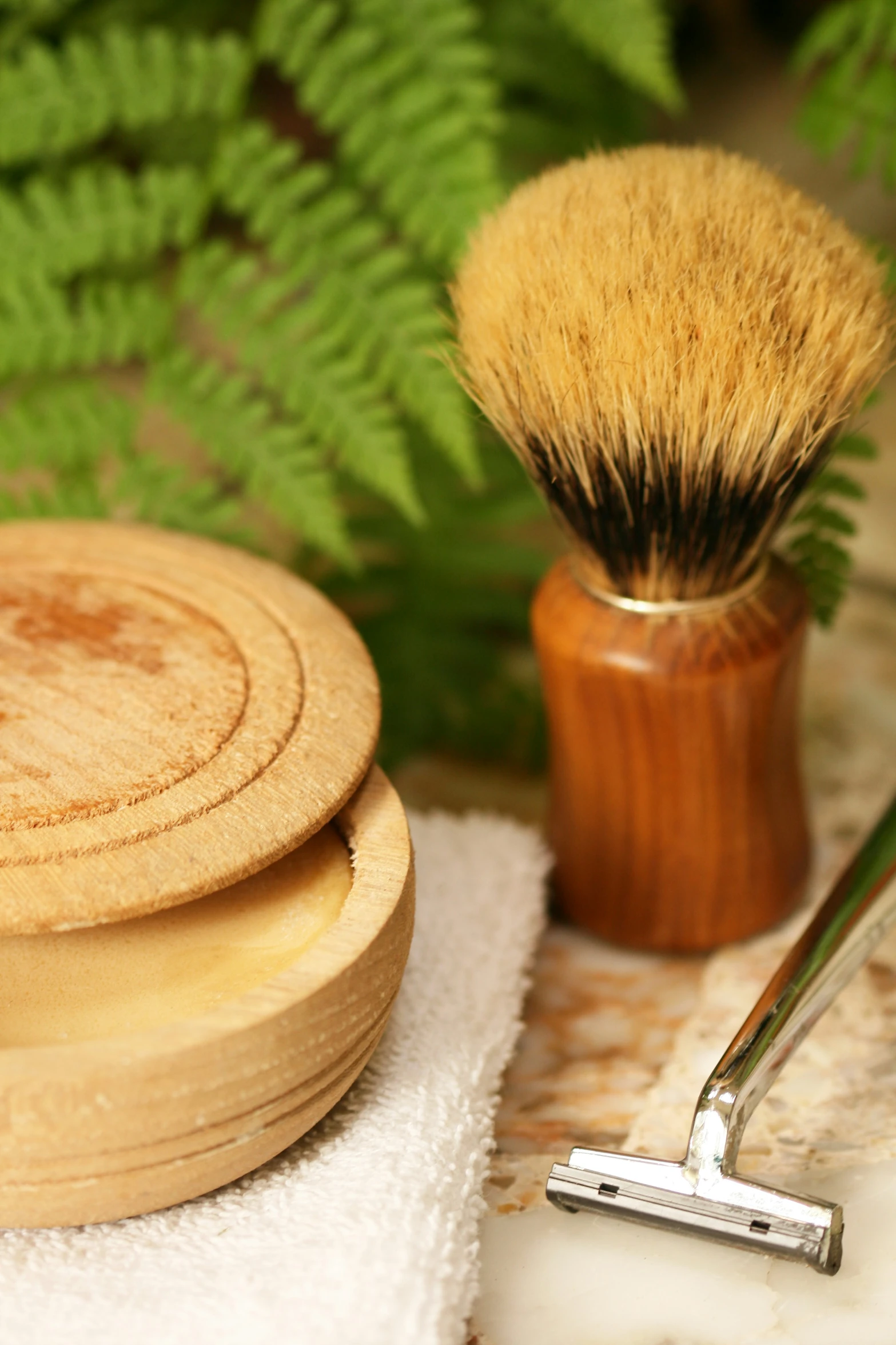 a shaving brush next to another on a white towel