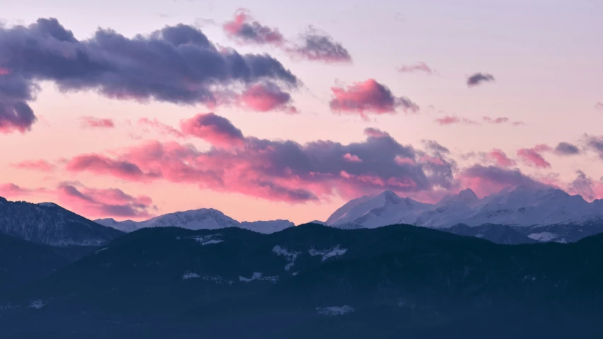 a very pink sky is shown over some mountains