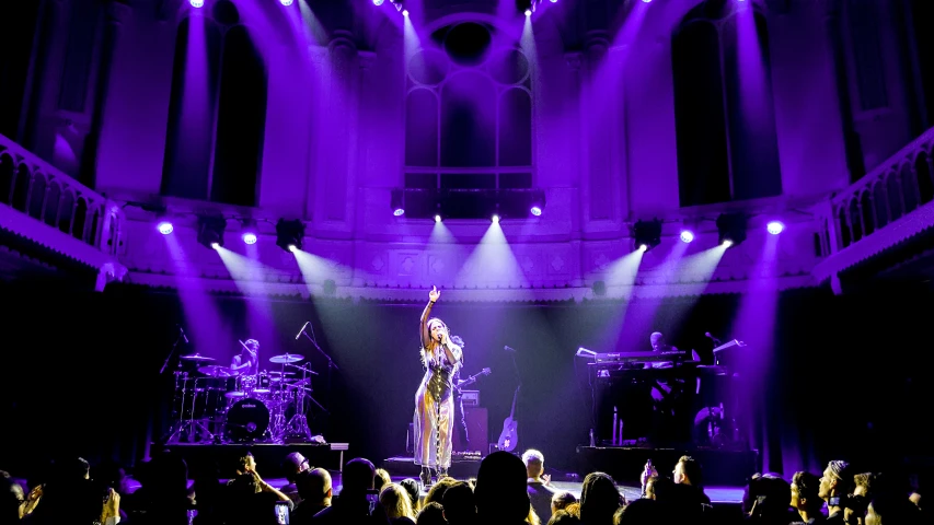 a woman that is standing on stage in front of people