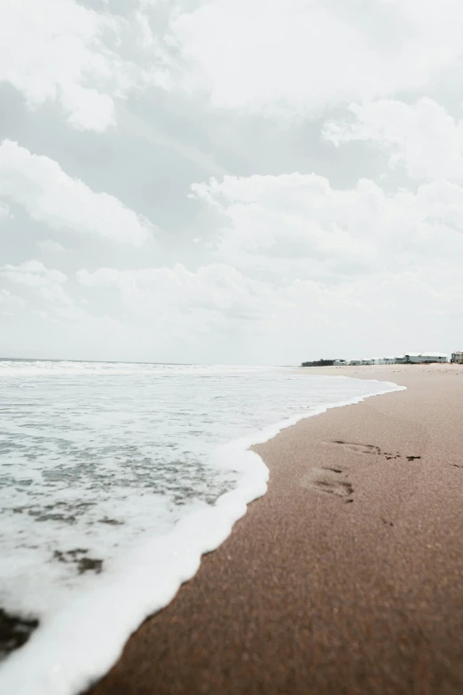 a couple walks on the beach holding hands