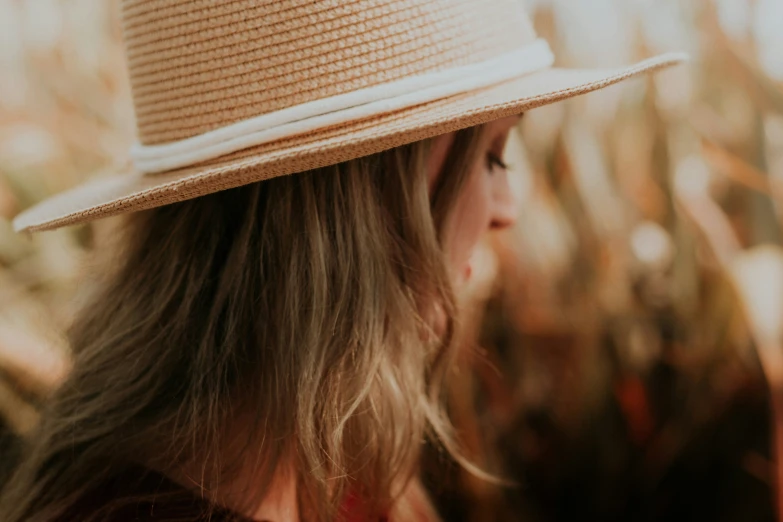 woman with long hair in the back wearing a straw hat