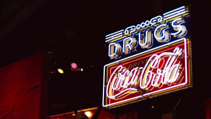 a neon sign advertising dr  in a dark city