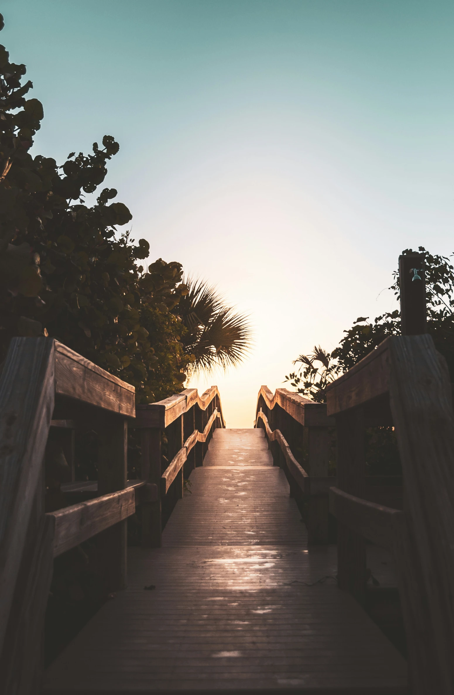 a wooden walkway leads to a body of water