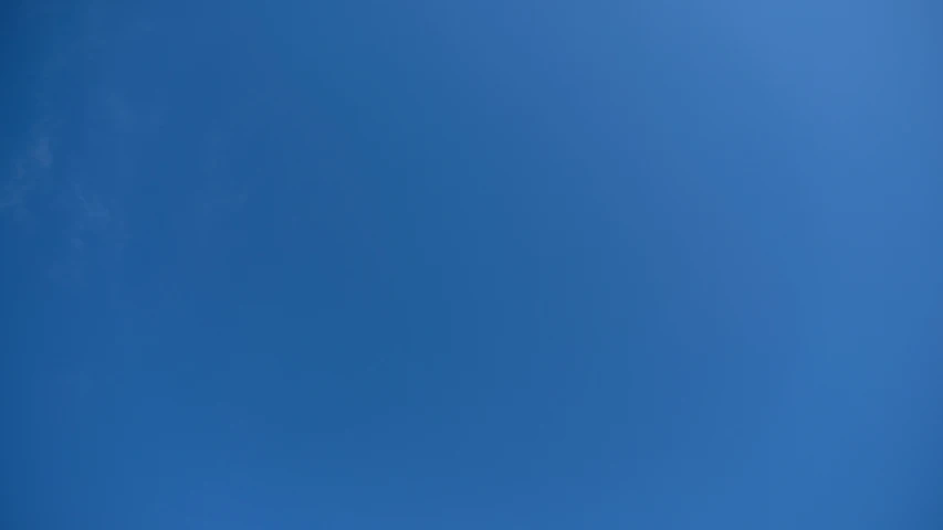 a plane flying in a blue sky
