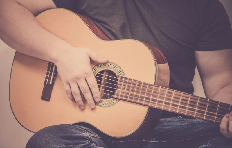 a man holding a guitar with both hands