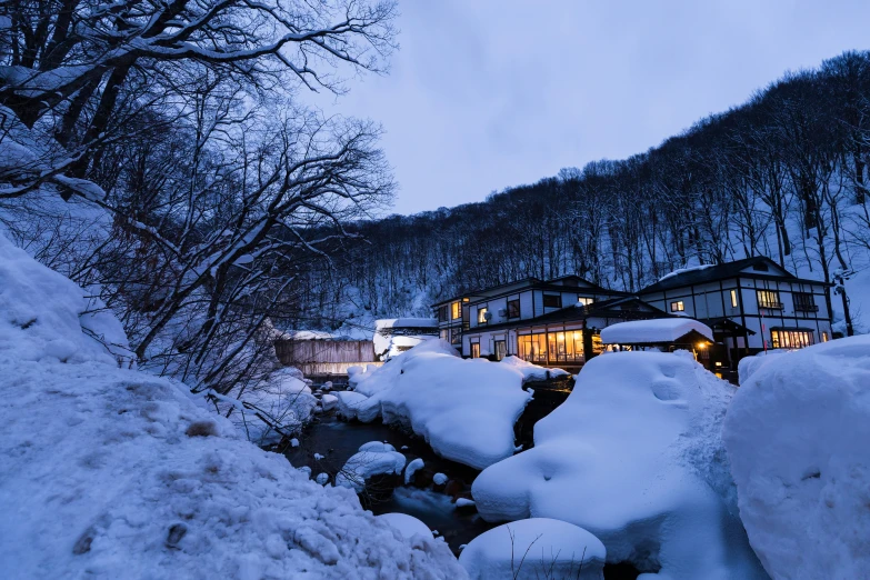 a home covered in snow next to snow piles