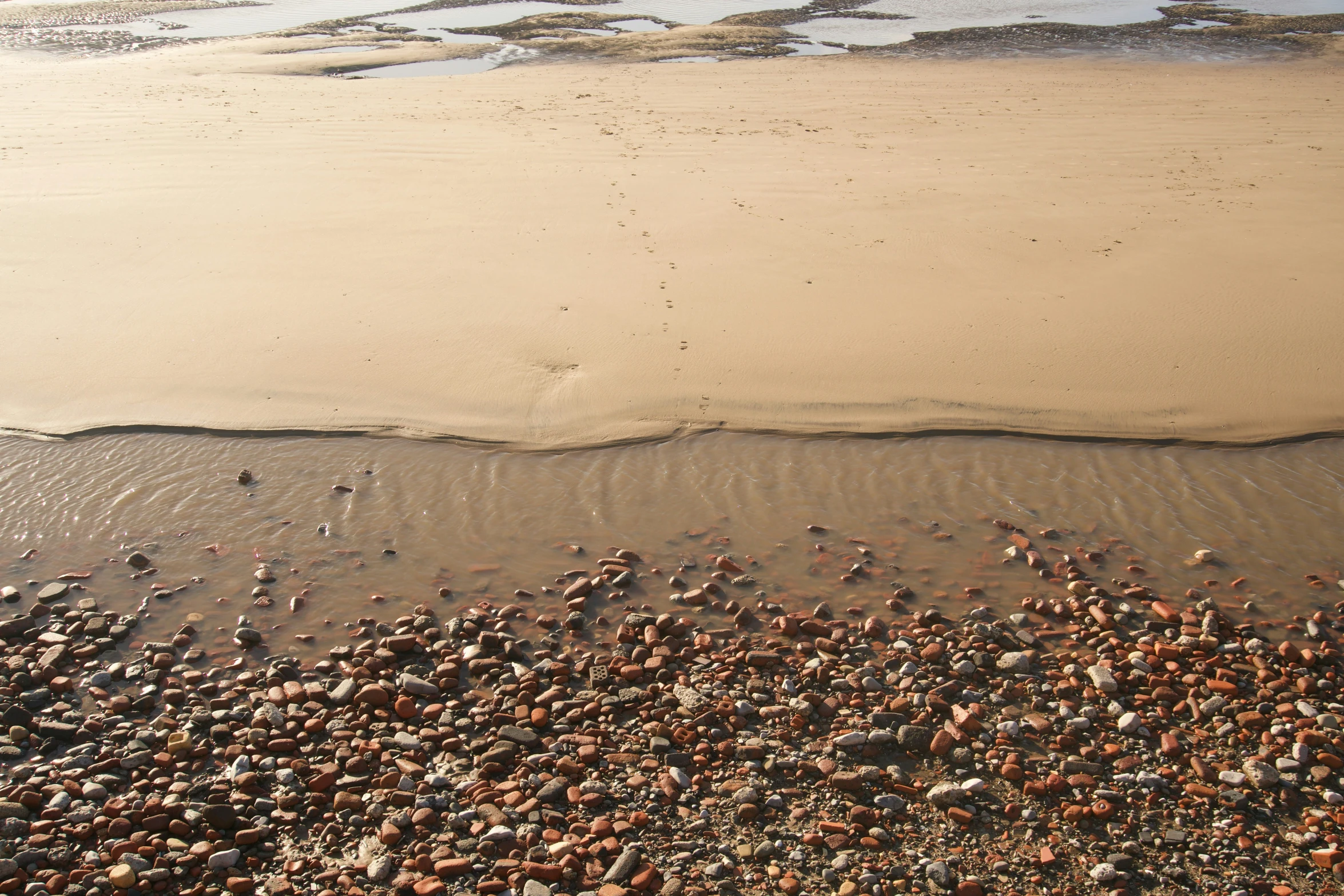 a picture looking down at the sandy shore line