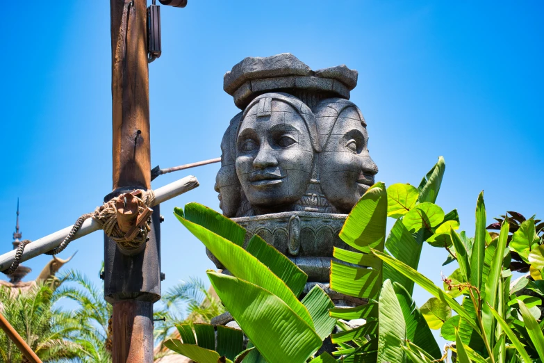 a statue sitting on top of a lush green tree