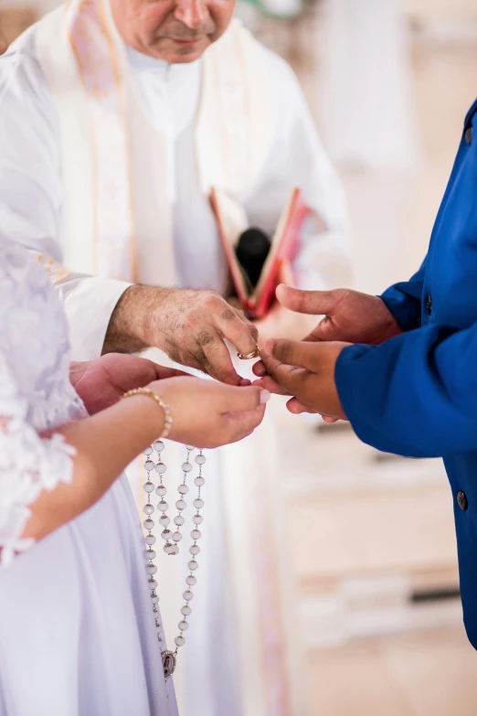 a man and woman putting their wedding rings on each other