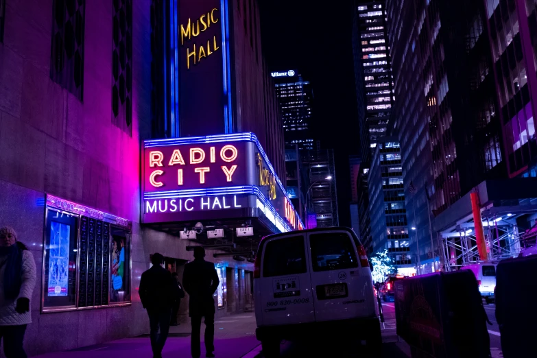 people are standing outside on the street in front of a radio city sign