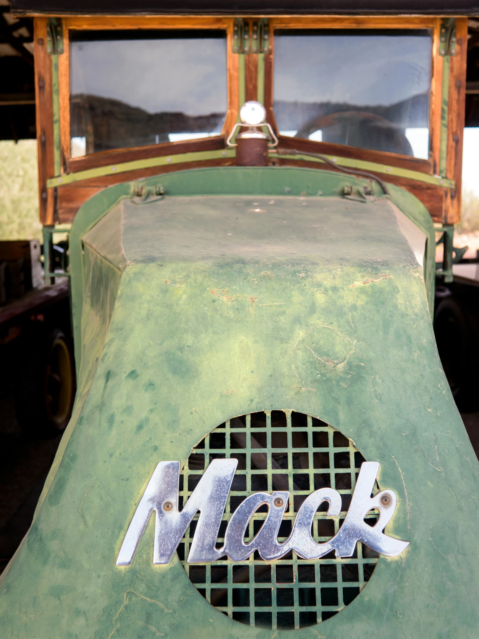 an old green truck has the word mack painted on it