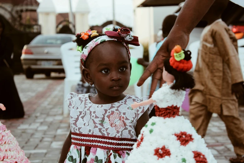 a little girl standing next to a fake wedding cake