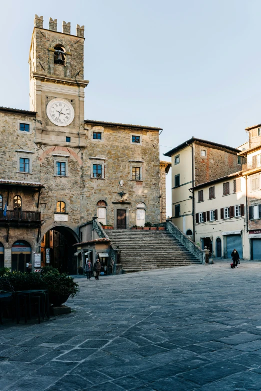 a large clock tower with people sitting around it